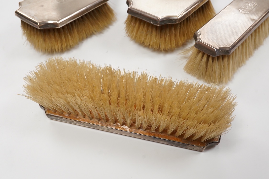 A 1930' matched engine turned silver mounted four piece dressing table brush set, William Comyns & Sons Ltd, London, 1933,36,38 & 39.